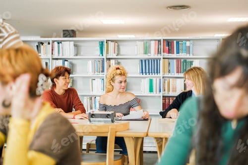 Preview: Group of students in the university library - focus on background group