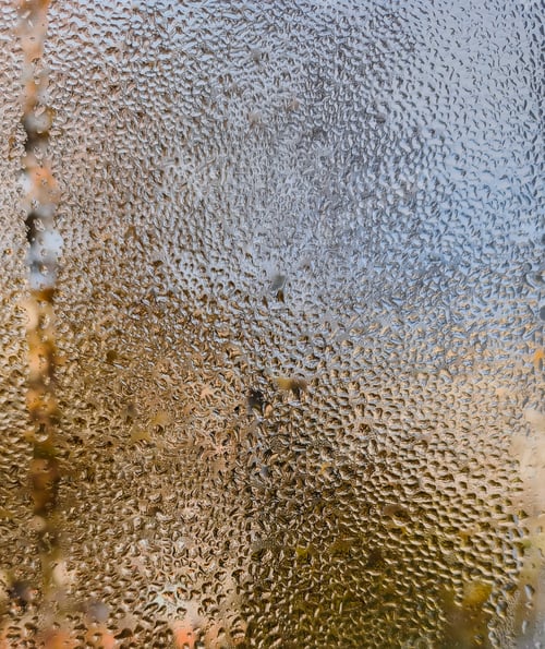 Preview: Close-up of water droplets randomly scattered on transparent glass surface,