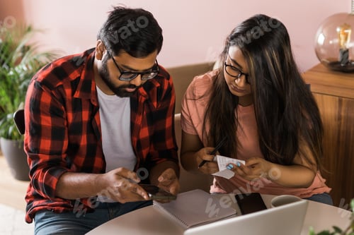 Preview: Serious wife and husband planning budget, checking finances, focused young woman using online