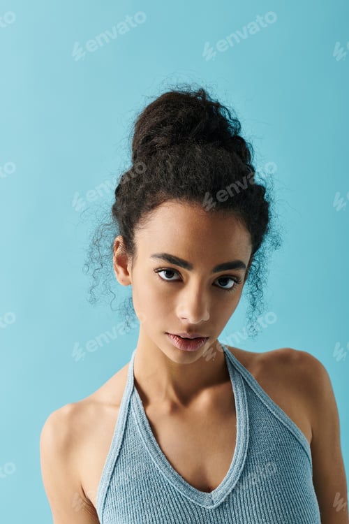 Preview: Young Woman Posing in Front of Blue Backdrop