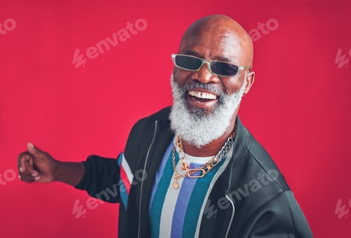 Preview: Studio shot of a senior man wearing retro attire while posing against a red background