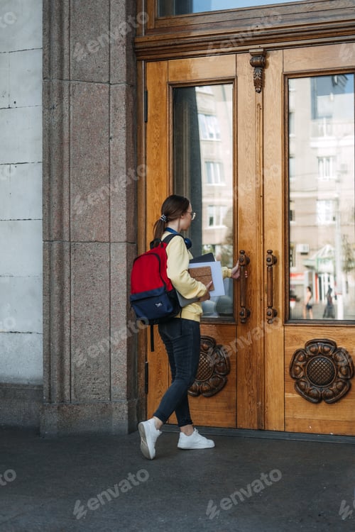 Preview: Scholarships for college students. Happy college student girl with laptop and books near college