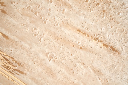 Preview: Photo of the texture of cosmetic foam or soap on a yellow background.