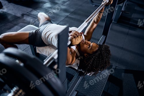 Preview: Serene strong sportswoman lifting the loaded barbell