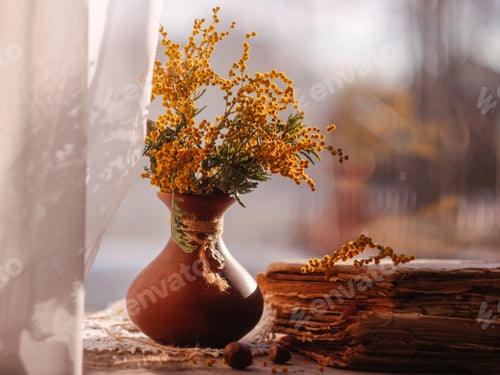 Vista previa: Bodegón vintage de primavera. Ramo de mimosa en jarrón de barro y libros antiguos