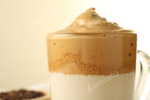 Preview: Delicious dalgona coffee in glass cup on blurred background, closeup