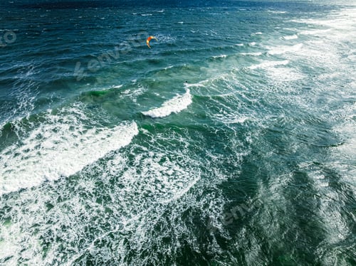 Preview: Aerial view of kitesurfer riding on waves at Baltic Sea.