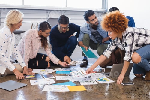 Preview: Creative business colleagues discussing over documents