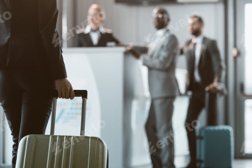 Preview: cropped shot of businesswoman with luggage walking to airport reception