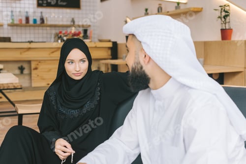 Preview: young beautiful muslim couple spending time in modern cafe