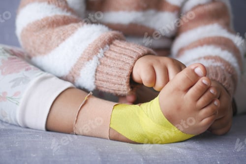 Preview: Elastic therapeutic yellow tape applied to child leg. Kinesio Taping therapy for injury