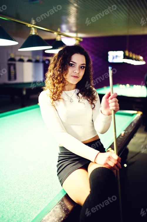 Preview: Young curly girl posed near billiard table