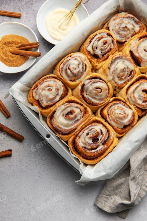 Preview: Freshly baked cinnamon rolls with cream cheese frosting in baking pan