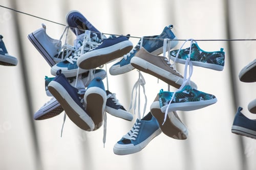 Preview: Pairs of sneakers and shoes hanging on cable