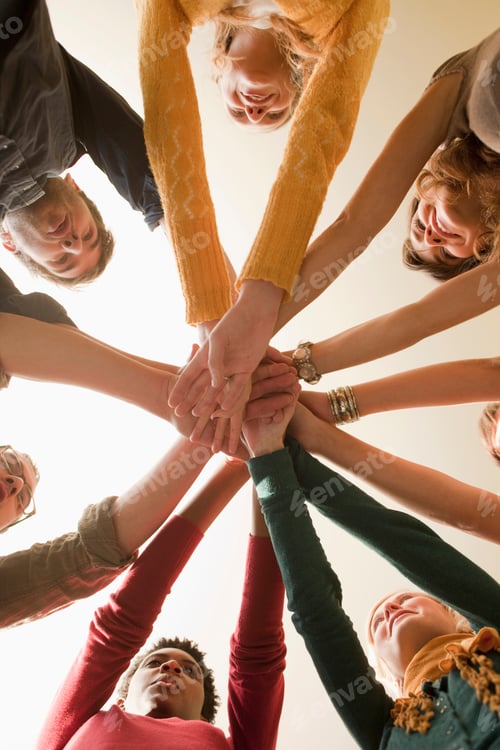 Preview: Germany, Leipzig, Group of university students putting hands together, low angle view