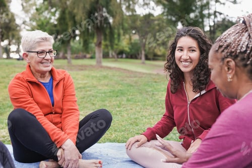 Preview: Multiracial women sitting and talking outdoor at city park