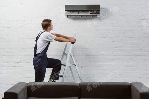 Professional Repairing Air Conditioner on Ladder Indoors