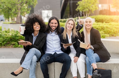 Preview: multiracial business coworkers having fun and eating outside