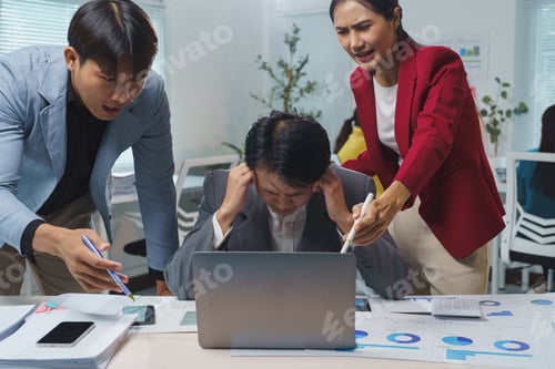 Preview: Two angry asian businesspeople are scolding their stressed male colleague sitting at his desk, cover