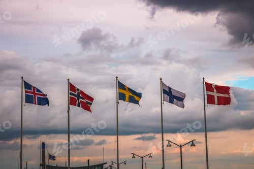 Preview: Flags of Scandinavian countries against a cloudy sky at sunset.