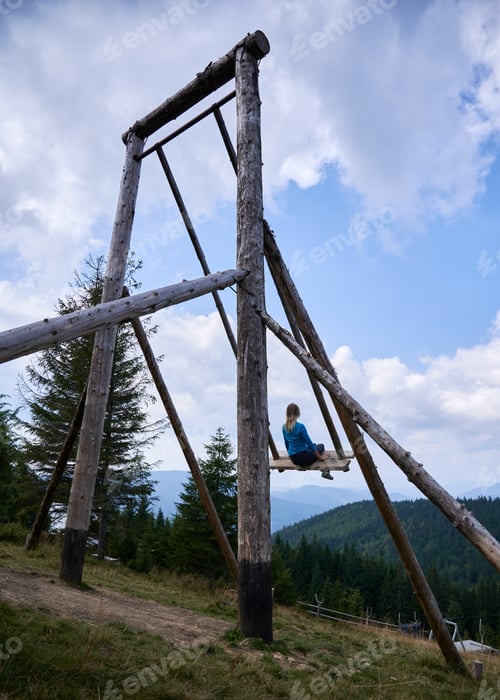 Preview: Swinging on huge swing in the mountains.