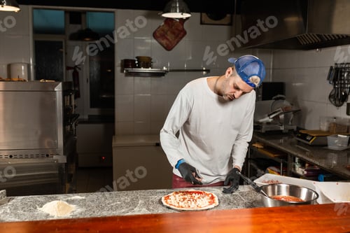 Preview: man cook prepares a pizza in a italian restaurant pizzeria