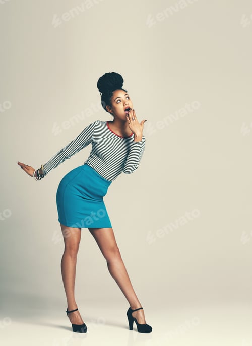 Preview: Studio shot of a fashionable young woman posing against a grey background