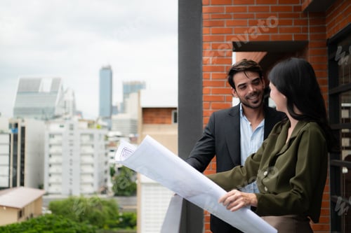 Aperçu: Businessman and businesswoman discussing project on the balcony of office building.