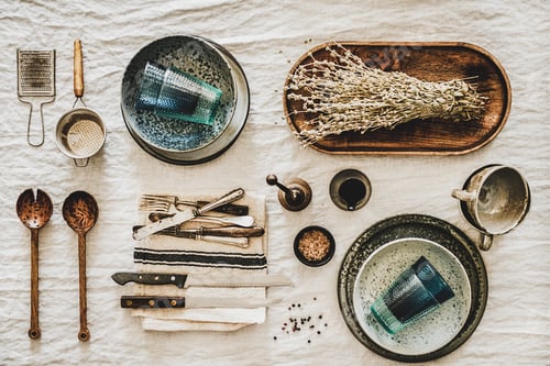 Preview: Various kitchen utensils and tablewear over linen tablecloth