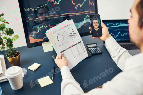 Preview: Businessman trading stocks online. Stock investor discussing numbers at graphs while video call