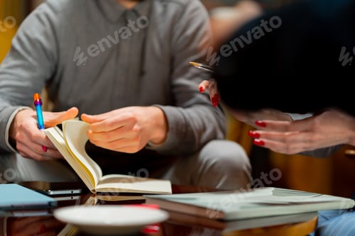 Preview: close-up of hands working on desk in office writing in notepad analyzing materials