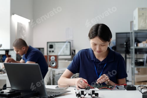 Preview: Asian Engineer Working on Electronic Device in Modern Lab