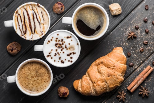 Preview: top view of cups of coffee, coffee beans, croissant and spices on table