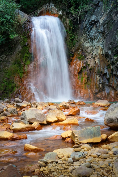 Preview: Red Rocks waterfall cascading over a rugged landscape of rocks in Negros Oriental, Philippines