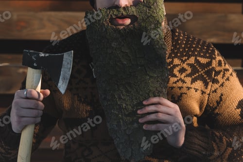 Preview: cropped shot of man with beard made of wood bark and axe in hand outdoors