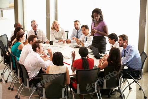 Preview: Businesswoman Addressing Meeting Around Boardroom Table