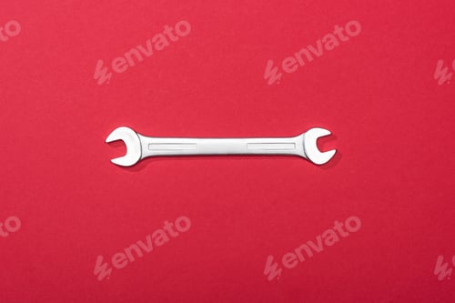 Preview: Top view of metal wrench on red background