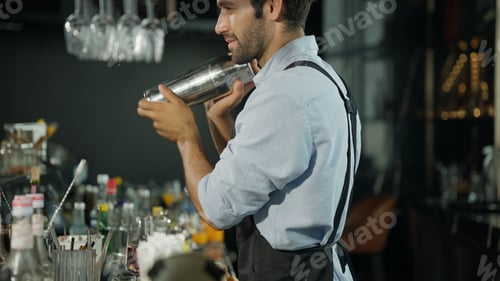 Preview: Smart bartender in black apron preparing cocktail