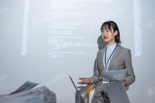 Preview: Young successful female coach with paper interacting with colleague