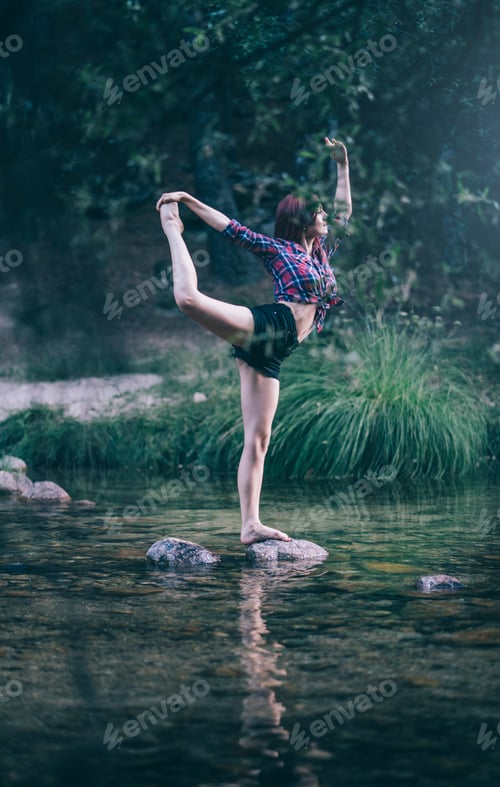 Preview: Pretty red haired girl performs exercises by the river.