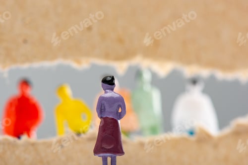 Preview: Selective focus of toy near hole in cardboard with people figures isolated on grey, concept of