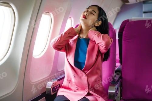 Preview: A young Asian female airline passenger sits by the window during the flight, pain during flight