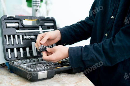 Preview: a worker hand taking the tool from the set case to do make the project