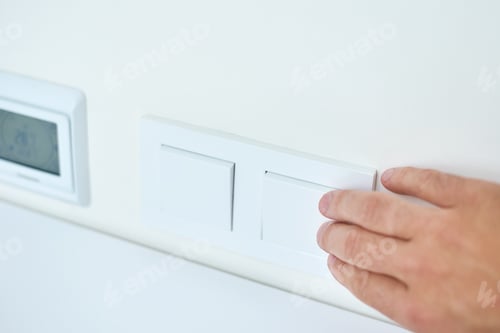 Preview: Hand is turning on or off on light switch, closeup