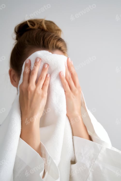 Preview: The girl wipes her face with a terry towel.