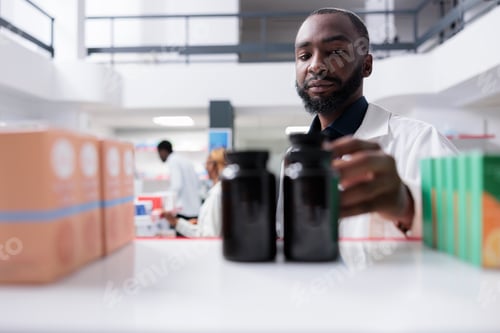 Preview: African american pharmacist taking supplement bottles from pharmacy shelf