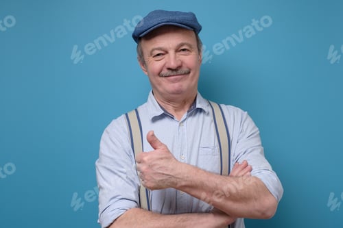 Preview: senior man in summer hat showing thumb up approving your choice