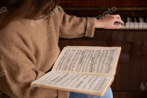 Preview: Close-up of musical notes in female hands.