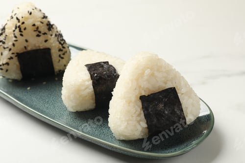 Preview: Rice balls (onigiri) on light table, closeup. Traditional Japanese dish
