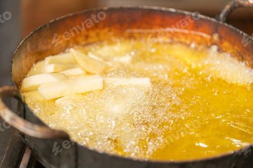 Preview: A pan with oil frying sliced potatoes